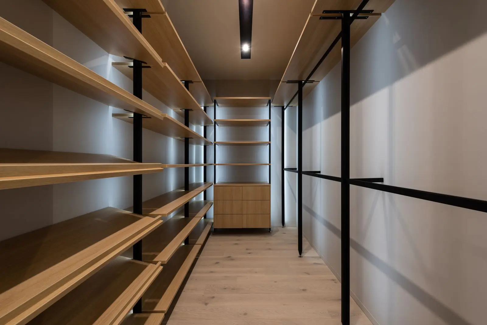 Interior de clóset con repisas de madera y ropa organizada